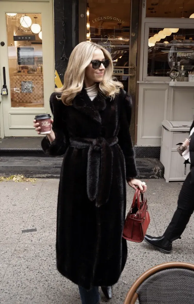 Annie in a long dark coat on a city street